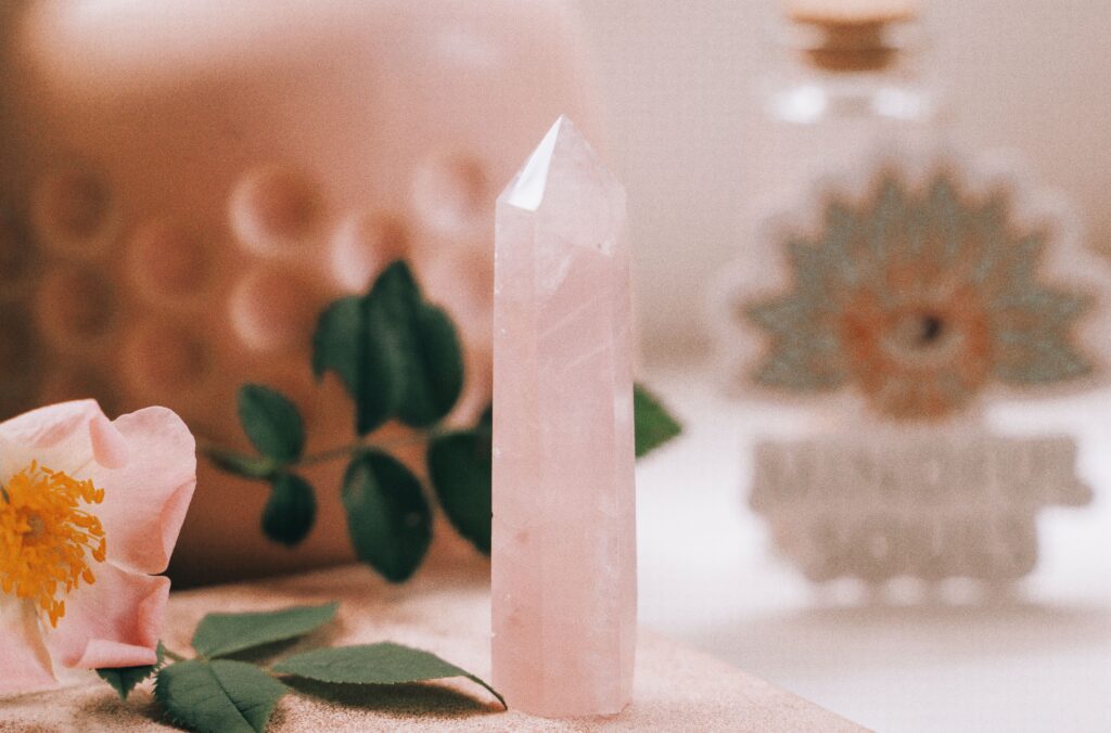 Elegant close-up of rose quartz with pink flower, perfect for meditation themes.